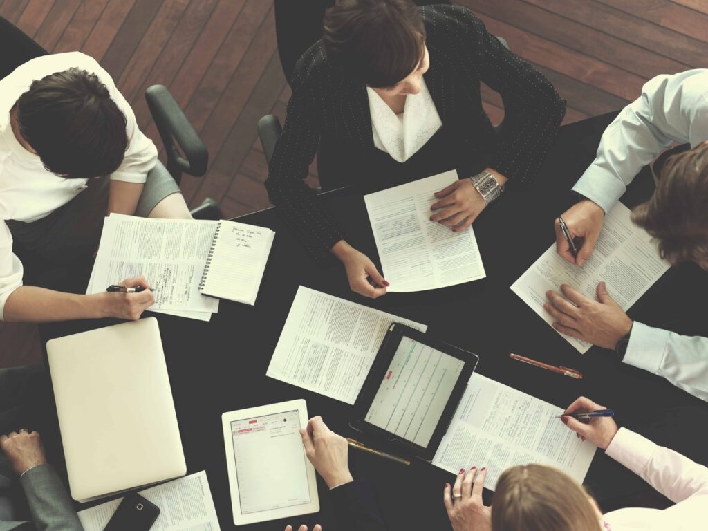 A diverse team of professionals discussing legal documents in a boardroom, representing legal risk management in Turkey.