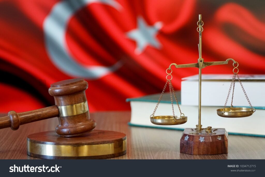 Турецкий адвокат в профессиональной офисной обстановке с юридическими книгами и документами, предоставляющий квалифицированные юридические консультации.