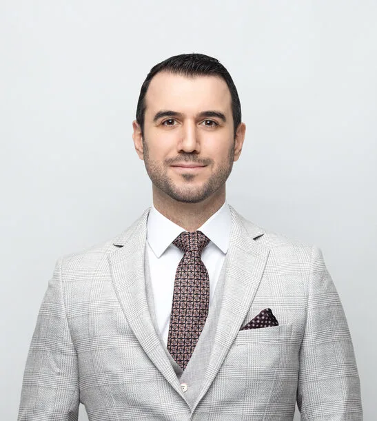 Portrait photo of a Turkish lawyer posing in his light color suit